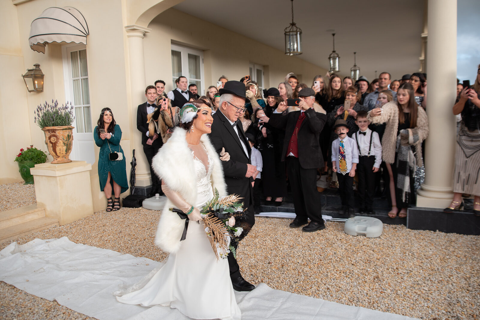 Bride and father walking the aisle at Terre Rouge, with the French manor and guests in attendance